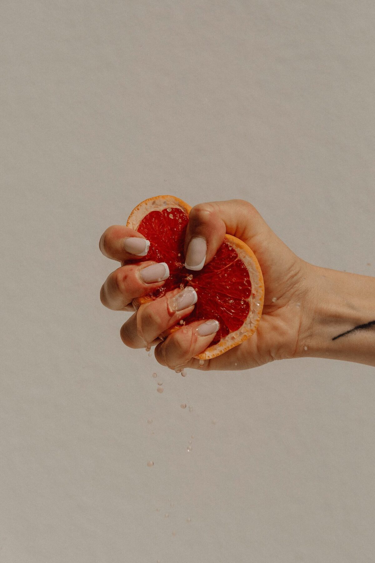 Les effets du stress chronique sur les troubles psychosomatiques : une main pressant un pamplemousse, symbolisant la pression constante et ses impacts sur le corps et l'esprit.