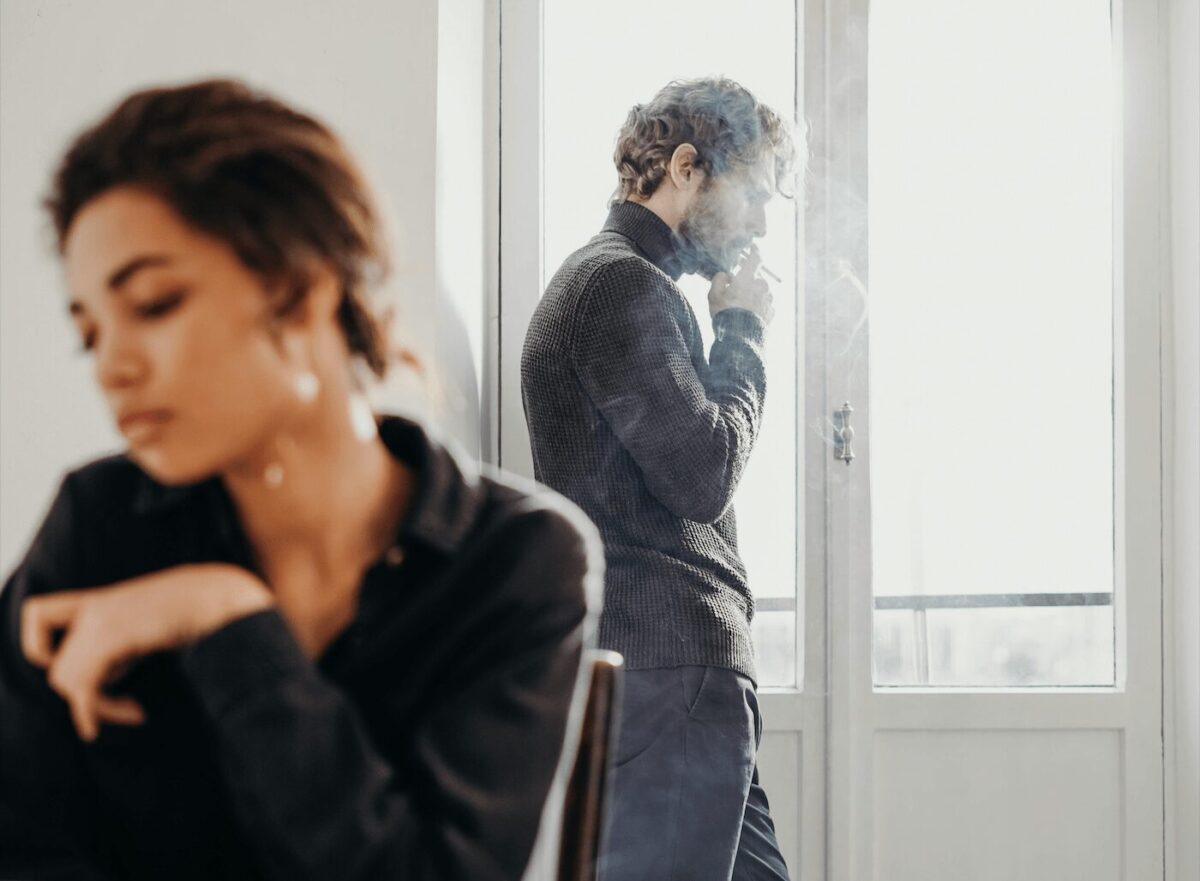 Un couple en pleine tension émotionnelle, illustrant un schéma d'attachement anxieux. L'un semble en quête d'affection, tandis que l'autre s'éloigne.