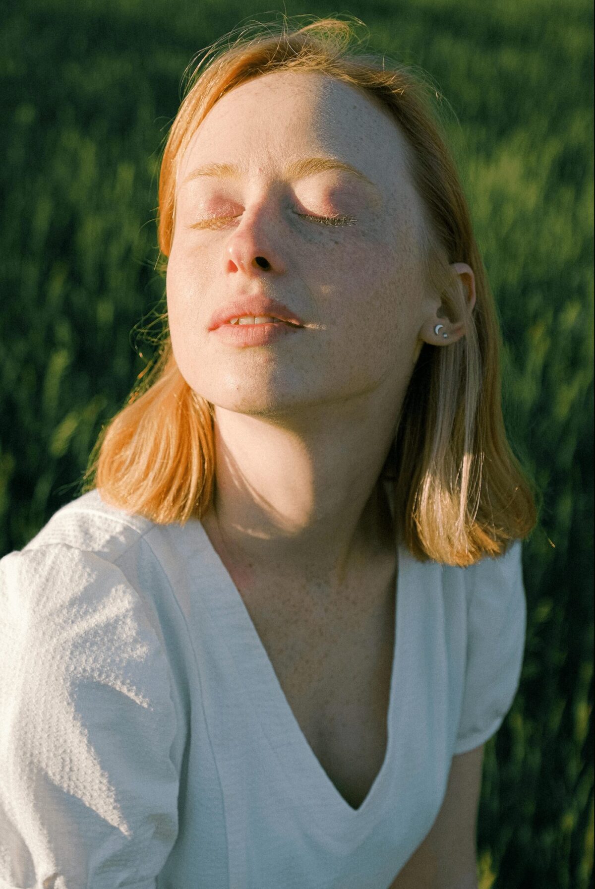 Femme pratiquant un exercice de respiration en pleine nature, les yeux fermés, profitant des bienfaits de la respiration consciente pour apaiser le stress.