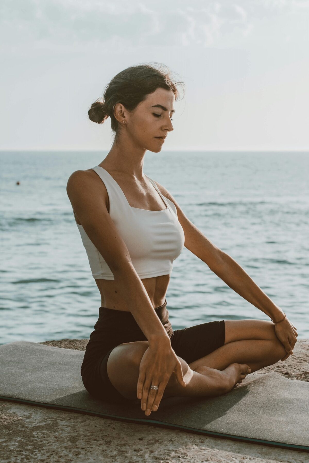 Femme pratiquant la respiration anti-stress 4-4-6-2 en pleine nature face à la mer, une technique de relaxation pour réduire l'anxiété et booster l'immunité.