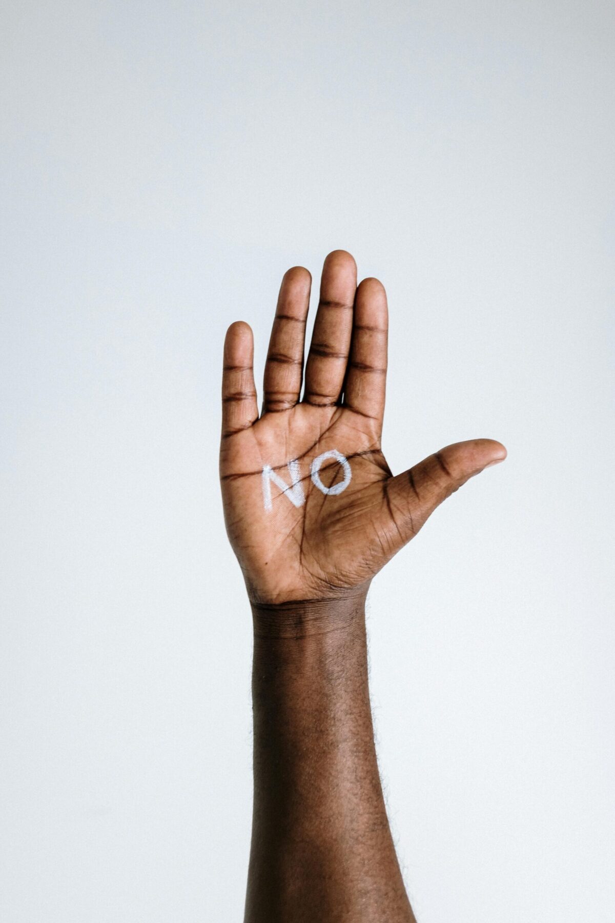 Une main avec le mot "no" écrit dans la paume. Illustrant le fait de mettre ses limites et de savoir dire non. 